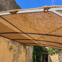 Toldo de fibra de coco bordeado con cuerda natural sobre una pérgola