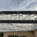 Cuerda de poliéster trenzado fijando una red de camuflaje blanca sobre una pérgola