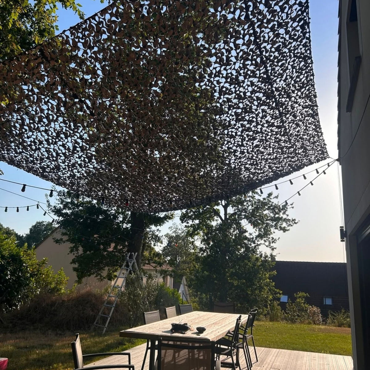 Red de camuflaje gris como sombra sobre una mesa de jardín