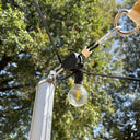 Tensor de cuerda con polea instalado en un mástil con guirnalda luminosa