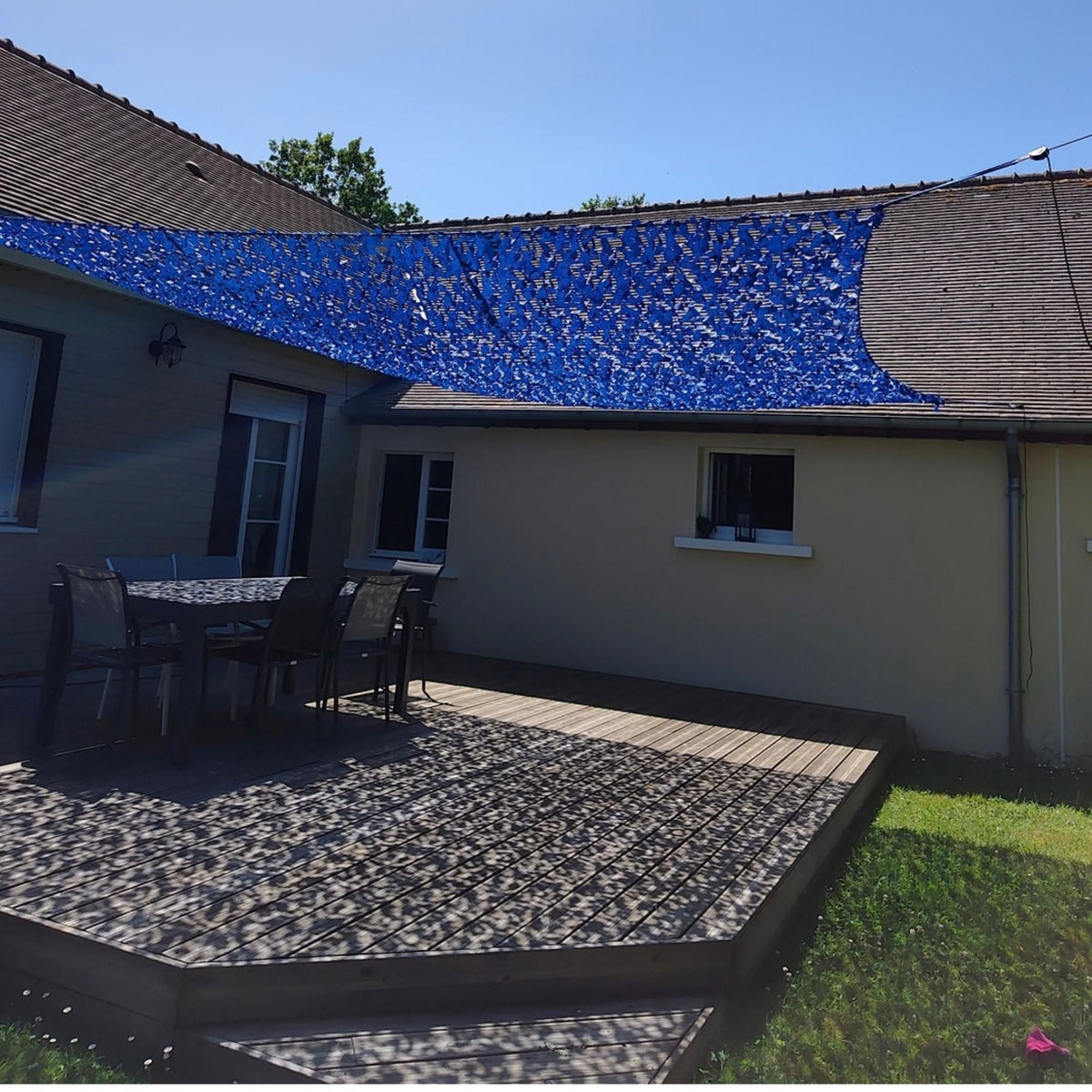 Red de camuflaje reforzada azul como toldo sobre una terraza de madera