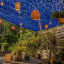 Red de camuflaje azul sobre una terraza decorada con farolillos