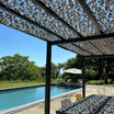Red de camuflaje reforzada gris sobre una pérgola junto a la piscina